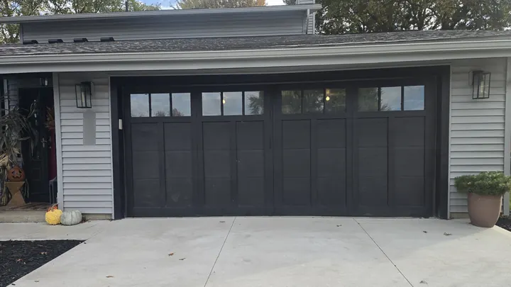 New black carriage-house garage door installed by Proactive Garage Door Repair