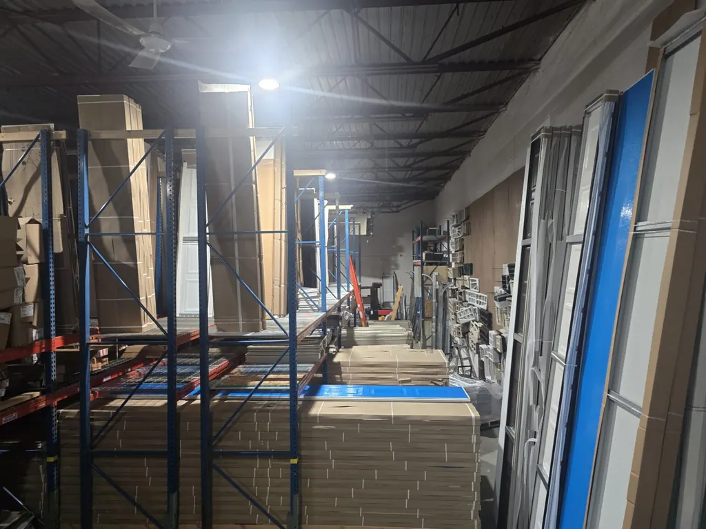 Warehouse shelves stocked with garage door panels and parts