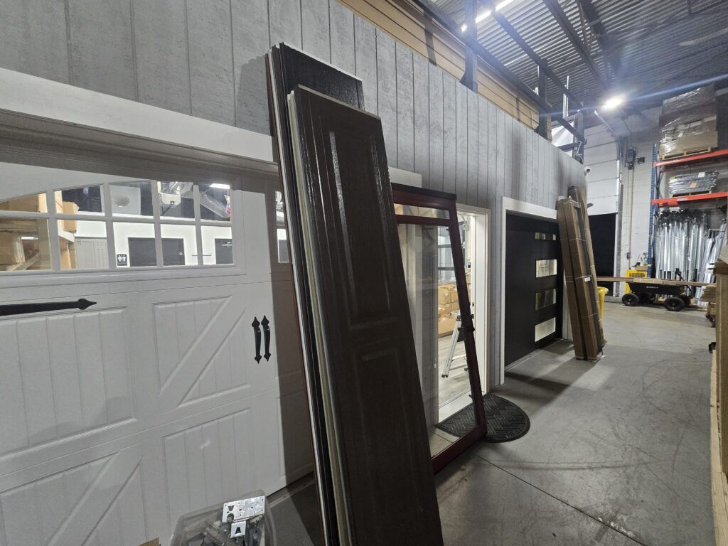 White carriage-style and black modern garage doors on display at Proactive Garage Door Repair