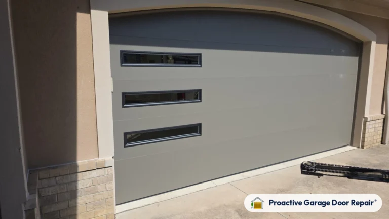 Side view of a new gray modern garage door with long windows installed by Proactive Garage Door Repair